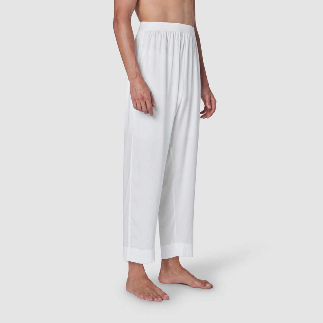 White wide-leg cropped pants with an elastic waistband, shown on a model from the chest down against a light gray studio background.